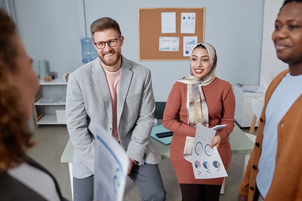 How to Choose the Right Branding Agency for Your Brand Vision three happy young intercultural colleagues looking at female economist